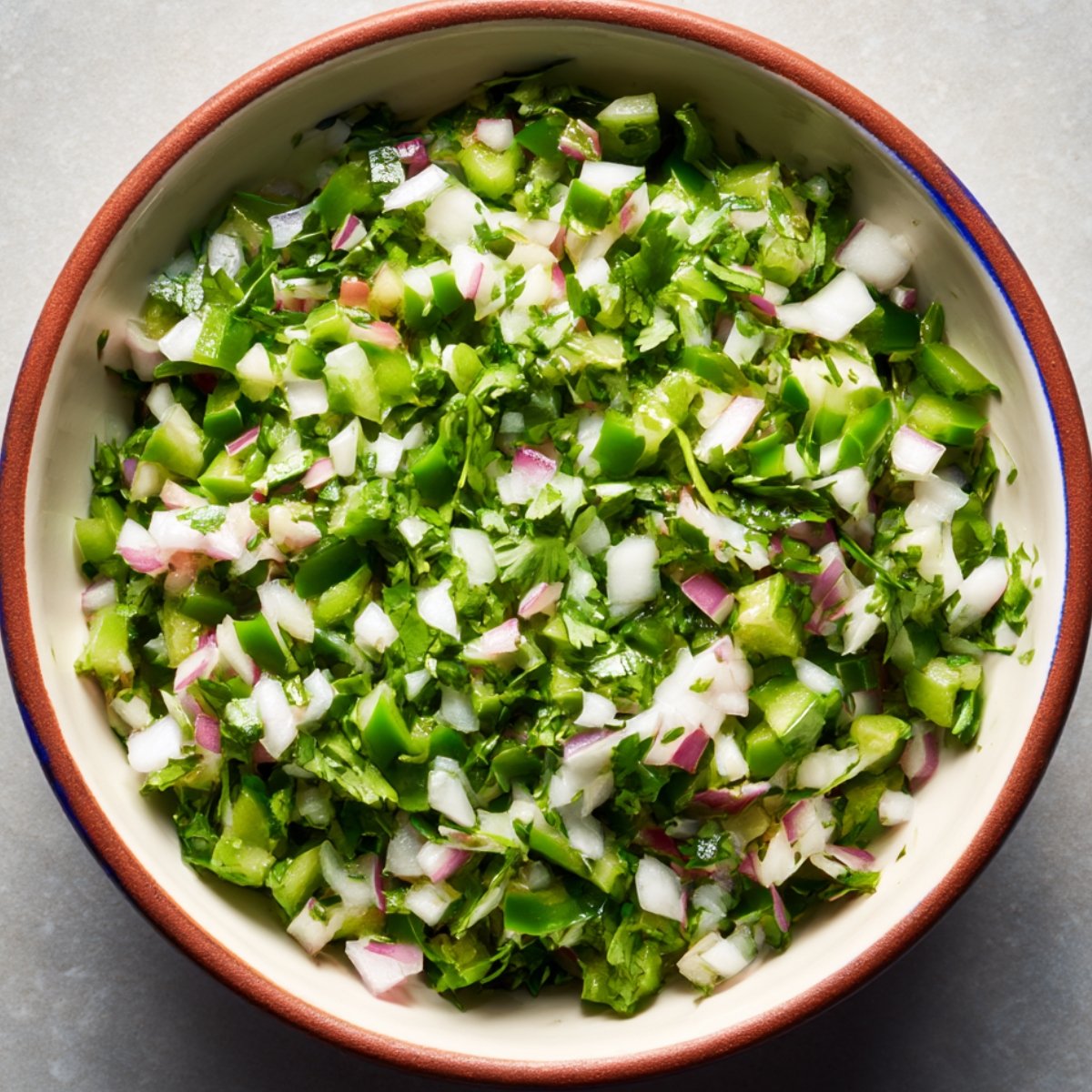 A fresh green salsa or relish featuring chopped green bell peppers, onions, and cilantro.