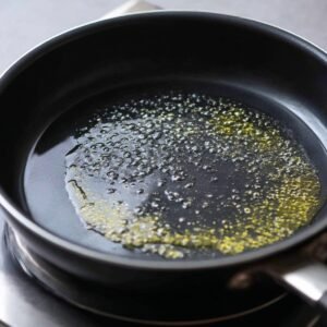 Nonstick pan with melted butter or oil bubbling, prepared for cooking tortillas.