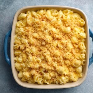 A baking dish of creamy macaroni and cheese with a golden breadcrumb topping, fresh from the oven.